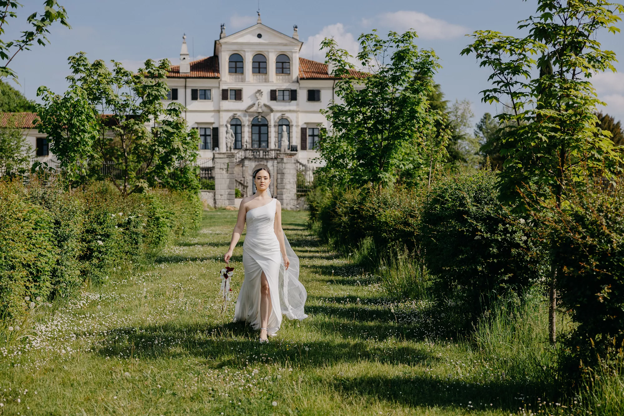 Blick auf ein Schloss mit einer Braut im Vordergrund - pure emotion wedding & events