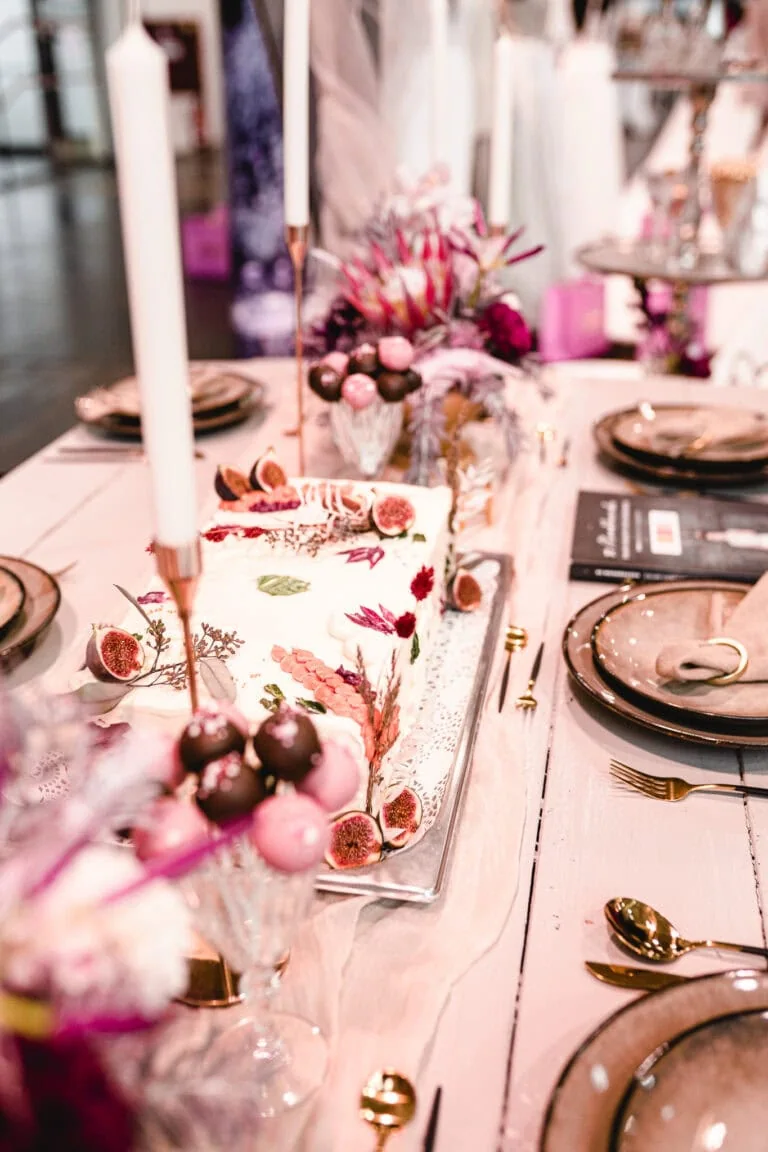 gedeckter Hochzeitstisch in hellen und dunklen Rosatönen